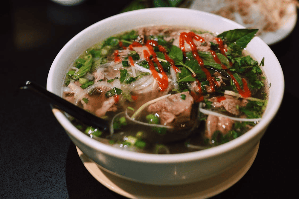A steaming bowl of Pho Thin Bo Ho, featuring clear broth, tender beef, and fresh herbs (Source: Pexels)